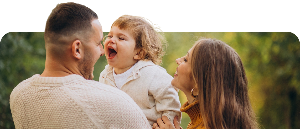 Pai e mãe brincando com a filha ao ar livre